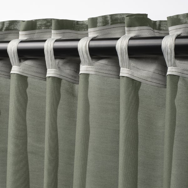 Green STENFRÖ sheer curtains hang with white heading tape, creating elegant pleats. Daylight softens, offering privacy.