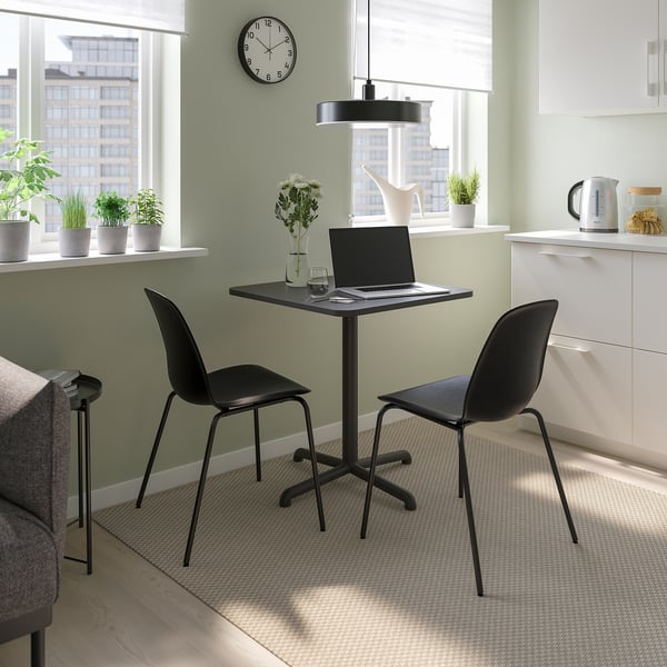 Black STENSELE dining set with small table and chairs. Fits laptop, vase, and saves space.