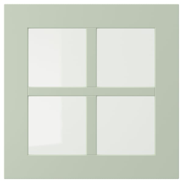 A light green, square-shaped, four-paneled window with a wooden frame.