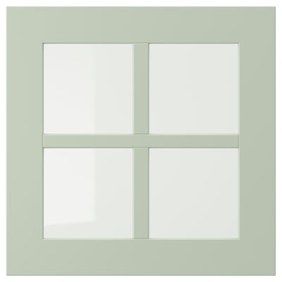 A light green, square-shaped, four-paneled window with a wooden frame.