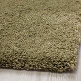 Soft, plush rug with thick, textured pile displayed on wooden floor.