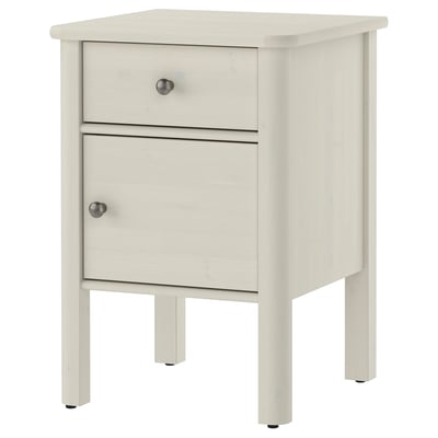 White STOREMOLLA bedside table with drawer and cabinet. Made of solid wood with metal knobs, rectangular shape.