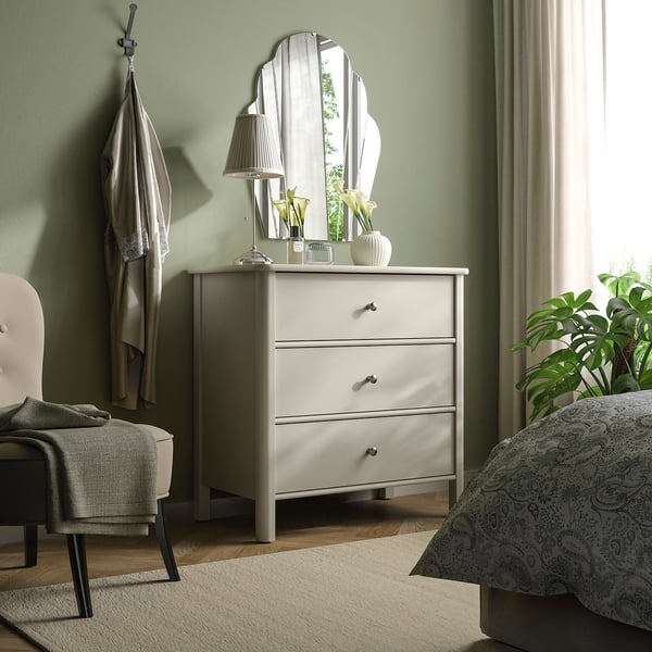 White STOREMOLLA dresser with mirror, lamp, and drawers in bedroom.