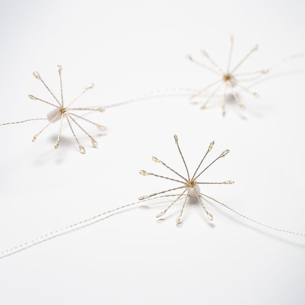 Three delicate golden wire stars hang, creating a festive mood.