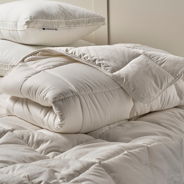 White STRANDMOLKE pillow with double piping and recycled materials.