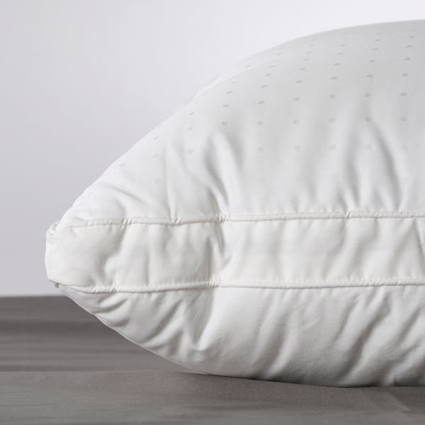 Close-up of a plush, high-quality pillow on a bed, showcasing its smooth fabric and supportive design.