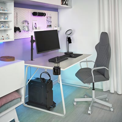 Modern office setup with white desk, black chair, monitor on adjustable STUBBERGET arm, keyboard, mouse, headphones, led lights, and decorations.