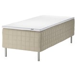 An IKEA STUVLAND cream-colored bed with a white mattress featuring a quilted pattern and metallic legs.
