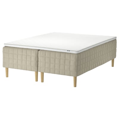 STUVLAND white bed mattress on beige base with wooden legs.
