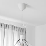 White pendant lamp cord set with a bulb and metal shade hangs from ceiling.