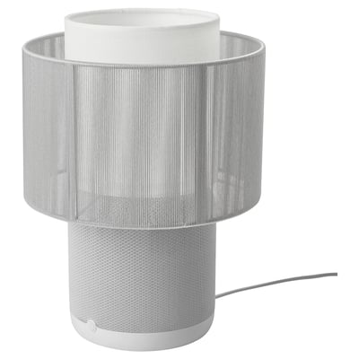 A modern white SYMFONISK lamp speaker with a cylindrical shape and textured fabric lampshade.