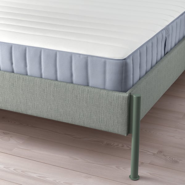 Modern bed with striped grey-green upholstery, adjustable sides for varied mattress thickness, and metal legs.
