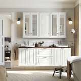 Modern white dual vanity unit with mirrored cabinets, timber countertop, towels, and mini stool. Classic bathroom design.