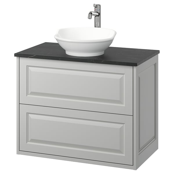 Modern bathroom vanity: light grey cabinet with round white basin & dark countertop.
