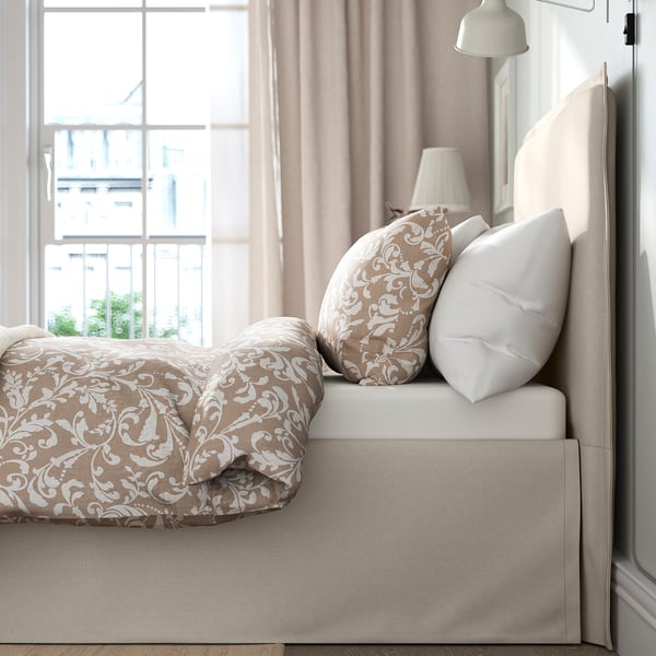 Bed with removable, machine-washable cover, padded headboard, and hidden storage under skirt.