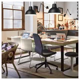 Modern dining area with TARSELE oak veneer table, featuring wire chairs and industrial pendant lights. Computers and accessories on the table.