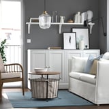 Modern living room with rug, white furniture, wooden table, chair, light fixture, decor, city view.