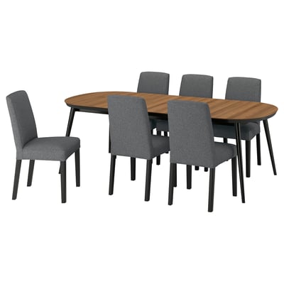 Modern 6-seat dining set with dark grey fabric chairs, oval walnut table, sturdy legs.
