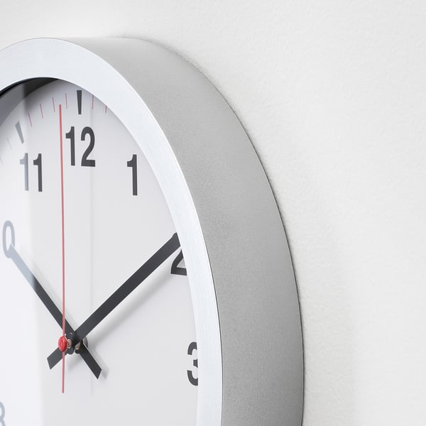 Modern wall clock with black hands, white face, and silver frame, indicating time as 2:20.