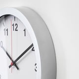 Modern wall clock with black hands, white face, and silver frame, indicating time as 2:20.