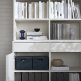 White bookshelf with gray storage boxes and decorative items, featuring a clean design.