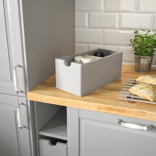 Kitchen counter with gray TORNVIKEN box, bread, and plant.