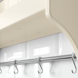 Modern kitchen shelf with white finish and chrome hooks.