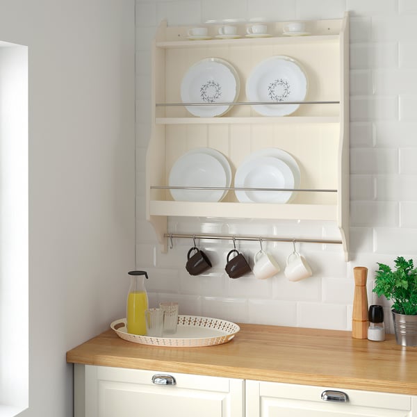 Kitchen shelf unit with white plates, cups, and juice bottle. Lightwood counter with tray. Compact, neat design.