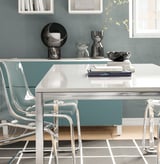 Modern conference table, TORSBY, silver, with high-gloss white top and chrome frame, surrounded by clear chairs.