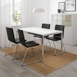 Modern TORSBY dining set with chrome legs and black chairs in minimalist living room.