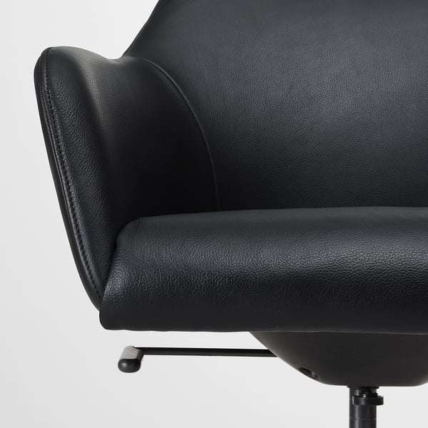 Close-up of high-quality black leather chair, showcasing its padded seat and back for comfort.