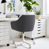 TOSSBERG office chair with white casters between white storage units. High-back, cushioned for comfort and small spaces.