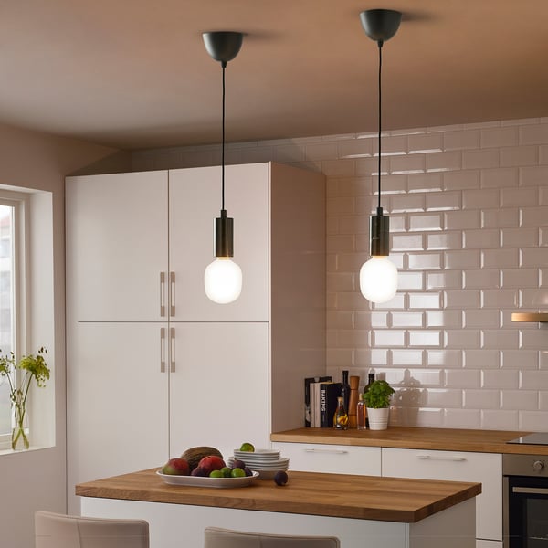 Modern kitchen with smart lighting, island fruit, and pink tile backsplash.