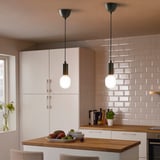 Modern kitchen with smart lighting, island fruit, and pink tile backsplash.