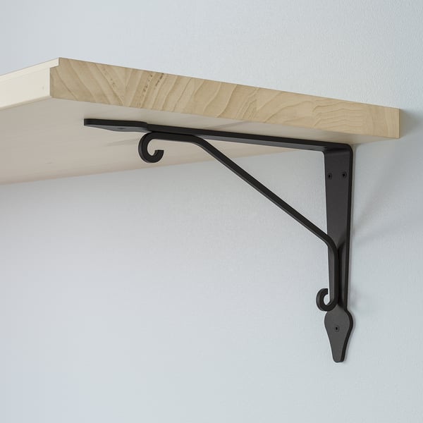 A wooden shelf supported by a metal bracket, securely attached to a wall. The shelf is smooth and light-colored, while the bracket is dark and sturdy.