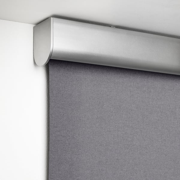 A modern block-out roller blind with soft edge, blocking sunlight and moonlight, mounted high on a white wall.