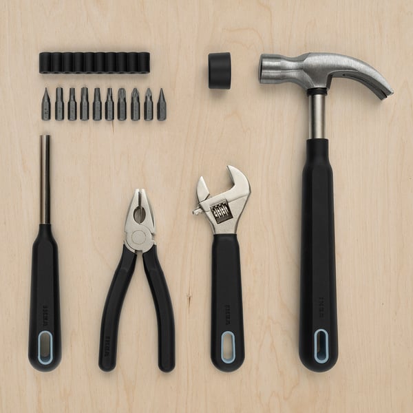 TRIXIG tool set, black, various shapes, durable materials, organized on wood.