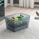 Metal mesh storage bin on carpeted floor, ideal for organizing and storing toys or other items.