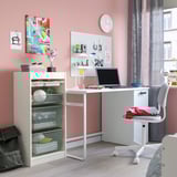 Bedroom with TROFAST storage, desk, laptop, and chair. Mesh compartments, wall art, trophy.