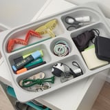 Organized storage tray with various kids items like pens, scissors, and accessories, perfect for keeping small things neat.