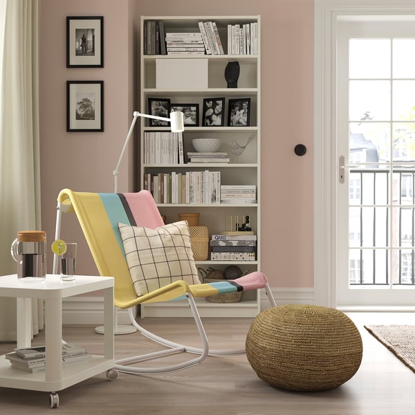TUMHOLMEN chair in living room. Brightly colored, retro design with high back and metallic legs.
