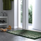 TUNNELBANA mat in dark green with white dots, rubber backing, rectangular shape, fits under the shoe rack, and extends beyond the doorway.