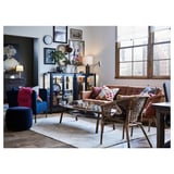 Modern living room with beige rug, brown sofa, wicker chairs, blue accents, city view.