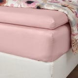 Bed fitted with pink sheets, elastic sides, crisp, soft, breathable.