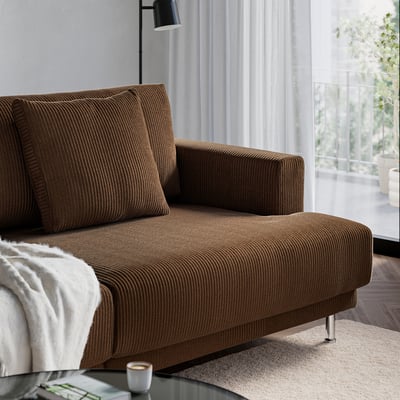 Brown, chunky sofa near a window with natural light, offering comfort and a cosy, inviting atmosphere.