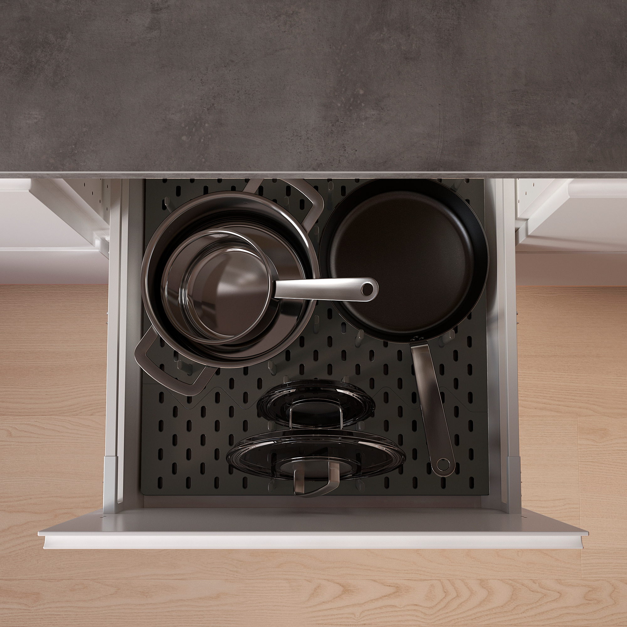 Organized kitchen drawer with black UPPDATERA pegs holding pots and pans, efficient storage solution.