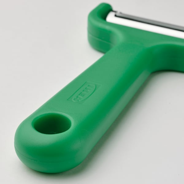 Green kitchen peeler with stainless steel blade, designed for long root vegetables. Secure handle with hanging hole.