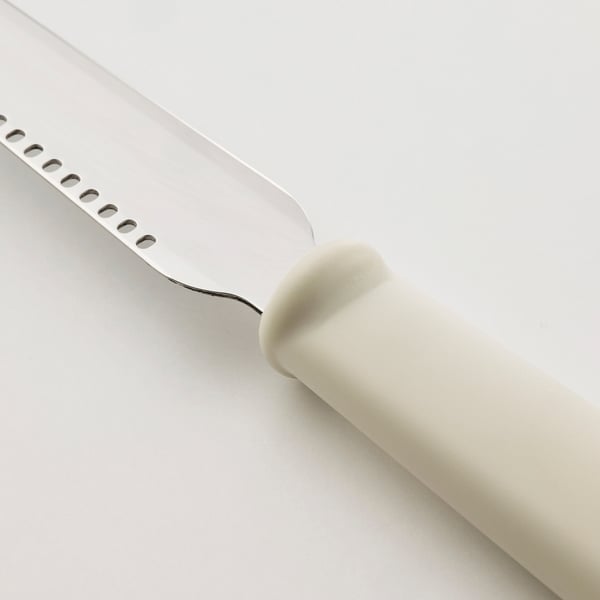 Small stainless steel tool with a white polypropylene handle, designed for spreading butter or icing, with a small curve for precise application.