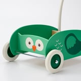 Infant walker shaped like green owl with large eyes, orange beak, and wings. Four white wheels and adjustable handle for stability and balance.