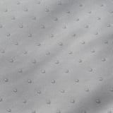 Close-up of soft, textured fabric. Small water droplets scatter, indicating durability and quality.